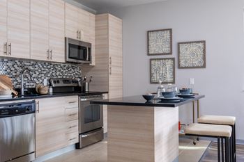 Reveal Heathrow apartment kitchen with quartz countertops and stainless steel appliances
